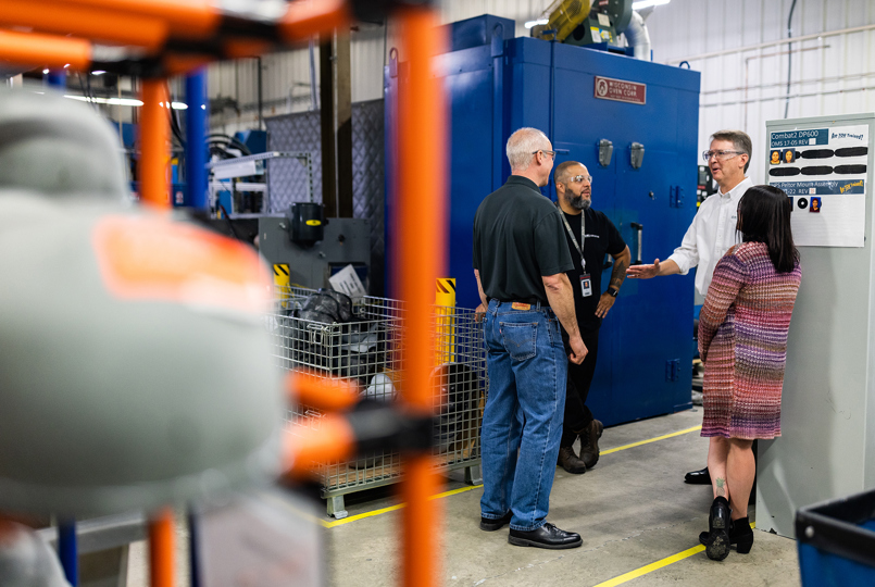 Three employees having a meeting on the production floor