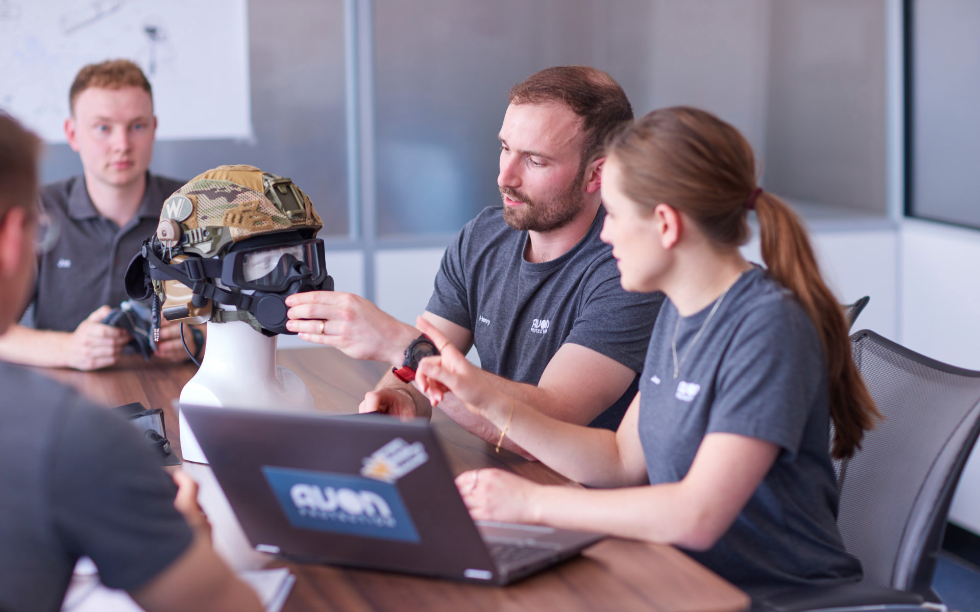 Two employees discussing a respirator and helmet